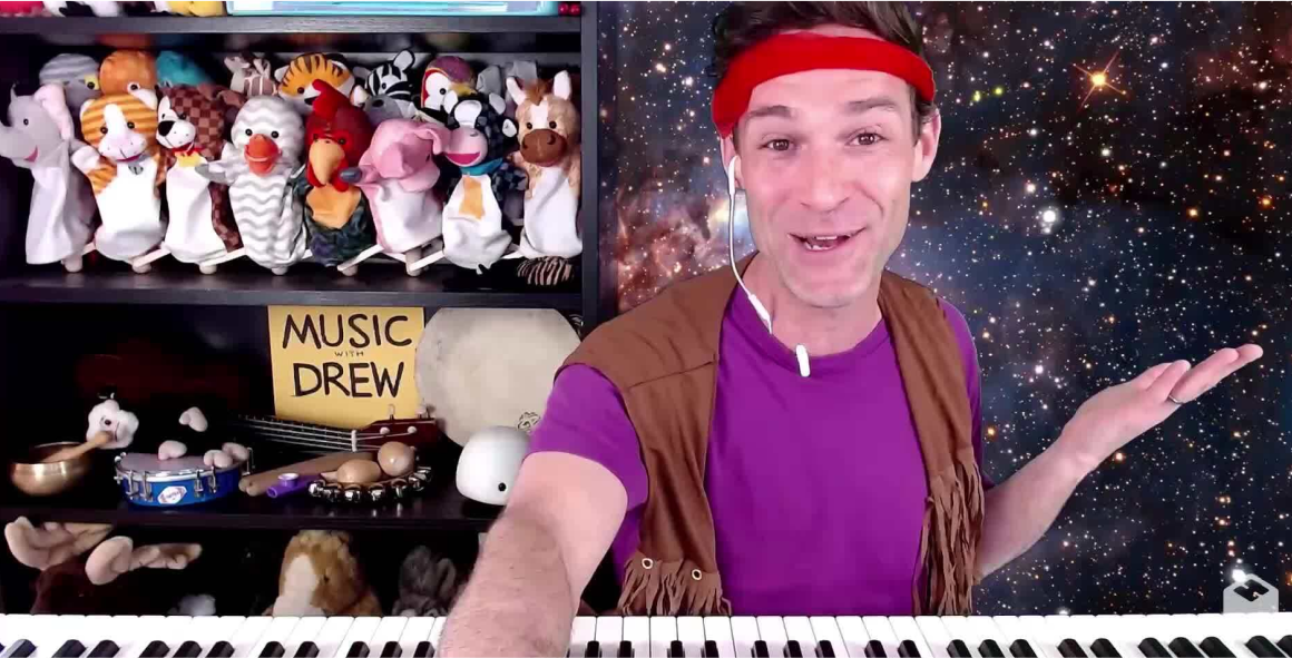 Music with Drew man in front of case with puppets