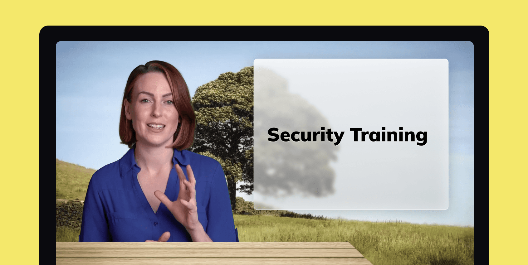 A woman presenting a security training video. She appears to be sitting at a bench in a park, and has a caption over her shoulder.