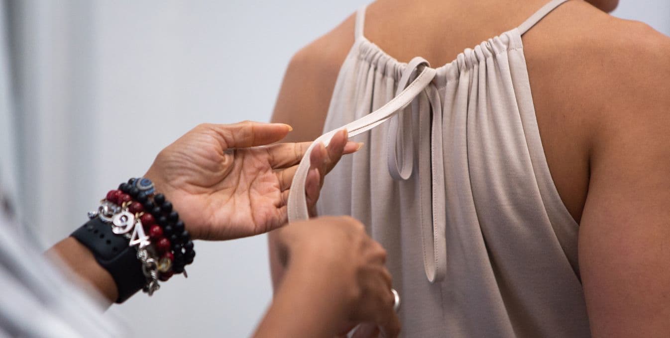 Photo of hands on the tie behind a dress