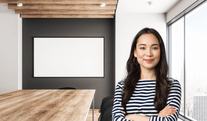 Person with long hair in board room with blank screen